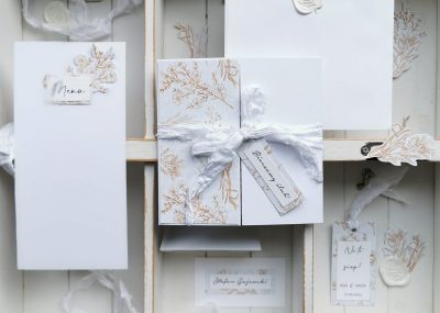 Minimalistyczne zaproszenia ślubne w klasycznej bieli ze złotem